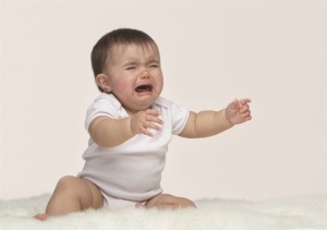 crying baby reaches out to be picked up