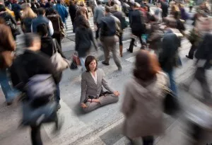 Mixed race businesswoman practicing yoga in busy urban crosswalk