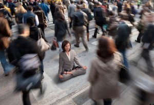 Mixed race businesswoman practicing yoga in busy urban crosswalk